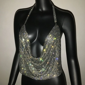 Dettaglio macro di strass scintillanti sul crop top allacciato al collo per feste