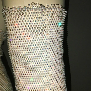 Détail de la robe résille à perles blanches avec des reflets strass irisés