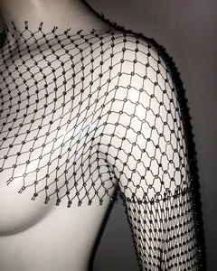 Close-up of black fishnet mesh top featuring sparkling rhinestones on diamond grid