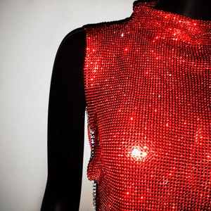 Detailed view of red rhinestone mesh sleeveless top with high neck and reflective crystals