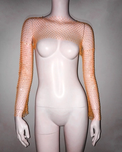 Close-up of bright orange fishnet crop top with sparkling rhinestones and mesh texture