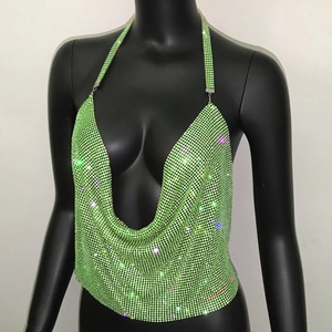 Dettaglio del crop top in rete metallica verde neon con strass brillanti e scollo a U