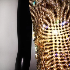 Close-up detail of high-density gold metal mesh vest with sparkling rhinestones