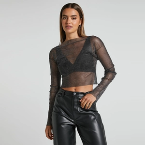 Dettaglio del crop top in rete nera con strass scintillanti e maniche lunghe