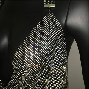 Dettaglio macro di strass argentati luccicanti su maglia metallica nera con fibbia
