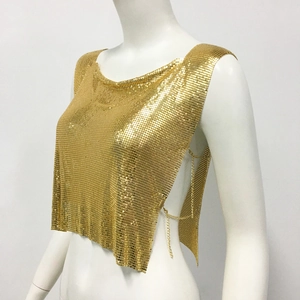 Détail du haut court en maille métallique dorée avec chaînes latérales et paillettes