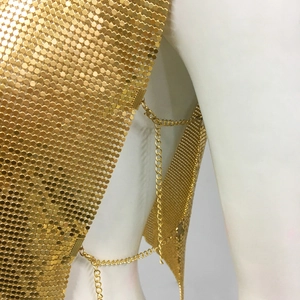 Détail de haut à paillettes métalliques dorées avec chaîne latérale et fermoir ajustable
