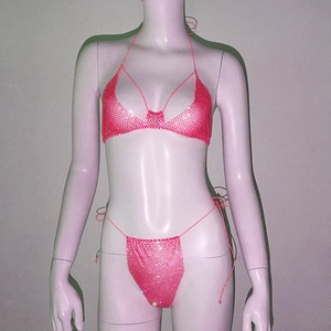 Detailed macro view of vibrant pink rhinestone mesh fabric on sexy triangle bikini set