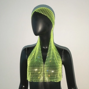 Détail du bonnet turban en maille jaune fluo avec strass brillants sur mannequin noir