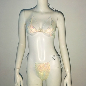 Macro detail of white mesh bikini with shimmering colorful rhinestones on fabric