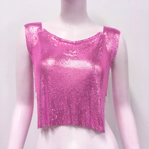 Détail d'un crop top à paillettes métalliques rose vif avec des chaînes latérales