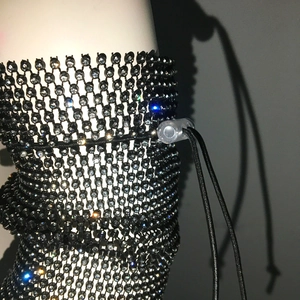 Detail of black rhinestone mesh cover with adjustable elastic drawstring and clear toggle