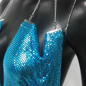 Close-up of blue metallic sequin fabric and silver chain strap on sexy halter dress