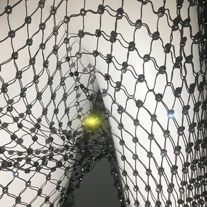 Close-up of black fishnet fabric with sparkling rhinestones on mesh intersections