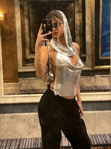 Detail of silver metallic sequin hooded halter top with open back and chain link mesh