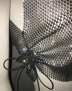 Detailed view of black rhinestone mesh top with adjustable side lace-up ties and crystals