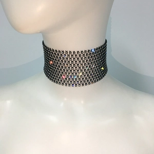 Détail macro du collier ras de cou en maille noire avec des strass colorés brillants