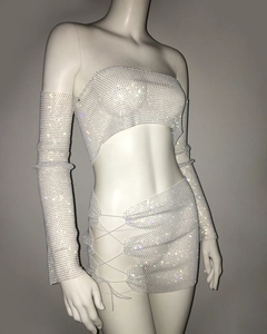 Detail eines glänzenden Strass-Dreiteilers mit Crop-Top, Schnür-Minirock und Ärmeln