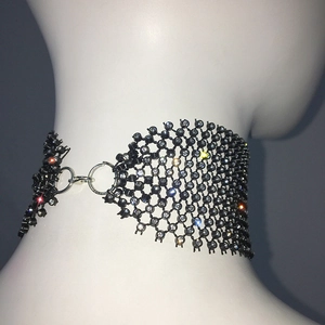 Détail macro du ras-de-cou large en strass avec structure en maille élastique brillante