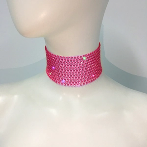 Gros plan d'un large collier ras-de-cou rose vif avec maille de strass étincelants