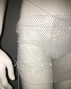 Close-up of white fishnet mini skirt with rhinestone embellishments and beaded grid detail