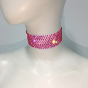 Détail d'un collier ras de cou large en strass rose avec structure en maille brillante