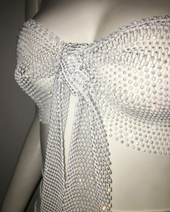 Détail d'un haut de bikini blanc perlé avec motif en maille strass et gros nœud central