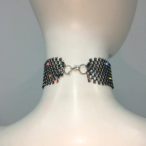 Détail d'un ras-de-cou en maille noire avec cristaux brillants et fermoir mousqueton