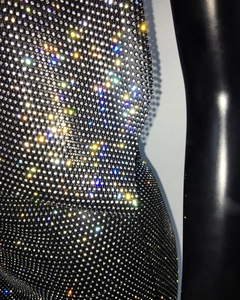 Close-up of black mesh fabric with sparkling rhinestones on backless party dress