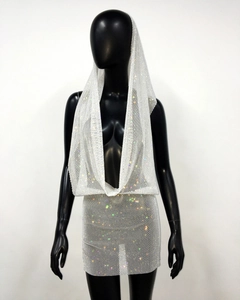Macro shot of sparkling rhinestones on sheer white mesh fabric of a two-piece party set
