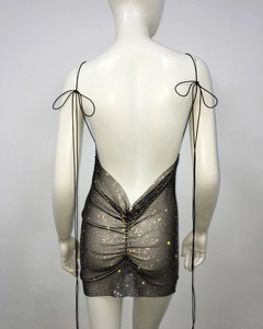 Detail of black rhinestone mesh dress featuring backless V-cut design and lace-up straps