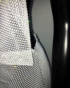 Detailed view of white rhinestone beaded mesh fabric on a halter party dress