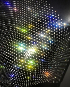 Gros plan macro de strass étincelants sur tissu mesh noir avec reflets brillants
