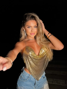 Détail du haut dos nu à paillettes dorées avec col en V profond pour style de fête