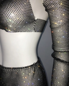 Detailed view of black fishnet mesh fabric with sparkling rhinestones on party outfit