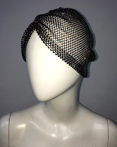 Detailed view of the black mesh headpiece with colorful rhinestones on a mannequin