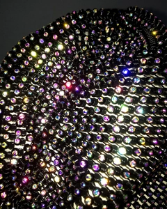 Macro shot of colorful iridescent rhinestones on a black mesh party hat accessory