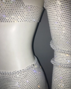 Close-up of white fishnet three-piece set with sparkling rhinestones for parties