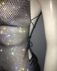 Detail of sexy backless rhinestone fishnet dress featuring black mesh with colorful crystals