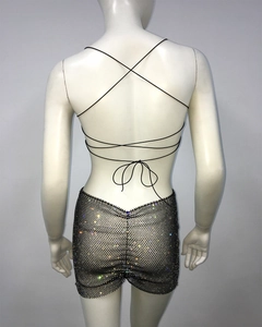 Detail of black mesh mini skirt with colorful rhinestones and backless lace-up set
