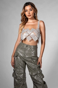 Detail of sequined halter top with metallic mesh and green cargo pants for women