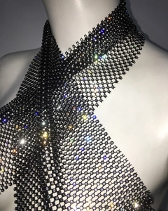 Détail d'un haut en filet noir avec strass brillants et design croisé sexy