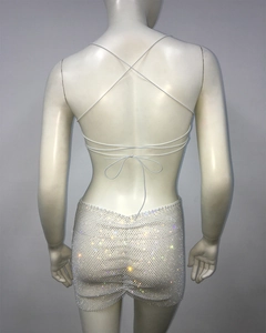 Detail view of sparkly rhinestone mesh skirt with white cross-tie top on mannequin