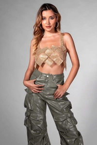 Detail of shimmering gold rhinestone crop top paired with olive green cargo trousers