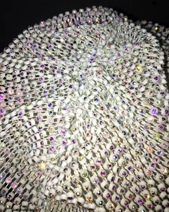 Macro shot of white mesh fabric with shimmering iridescent rhinestones for party hats