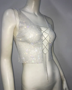Macro shot of silver rhinestone chain vest showing sparkling crisscross metal straps