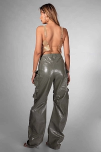Back view of a gold sequin backless top paired with dark green cargo pants