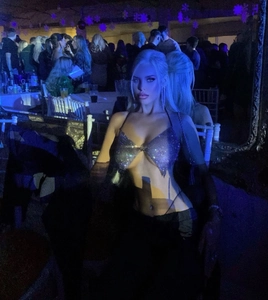 Close-up of a sparkling rhinestone butterfly halter top in a vibrant nightclub setting