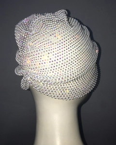 Detailed view of white beaded turban cap with colorful rhinestones on a mannequin head