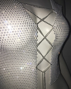 Detail of white beaded vest featuring silver metal chain lacing and rhinestone textures